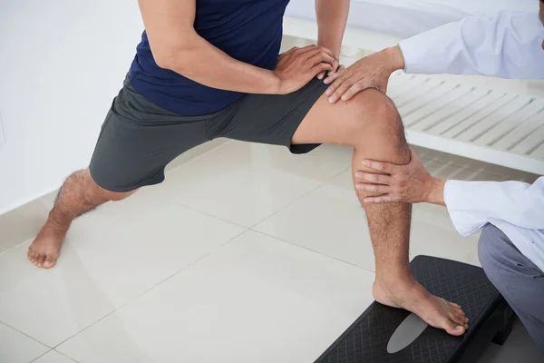 Imagem Cortada Fisioterapeuta Dando Terapia Joelho Para Homem Jovem — Fotografia de Stock