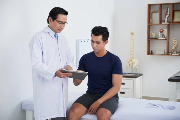 Asiatischer Physiotherapeut Zeigt Jungen Patienten Ergebnisse Medizinischer Tests — Stockfoto