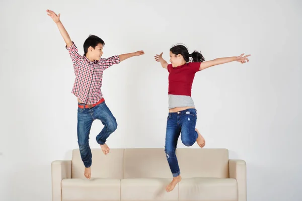 Feliz Emocionado Saltando Sofá Carreras Mixtas Niños —  Fotos de Stock