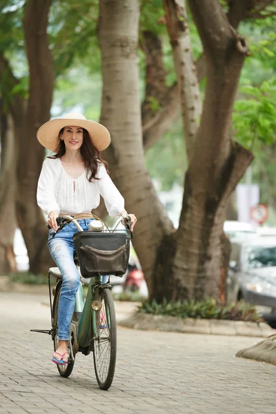 帽子骑自行车的可爱的妇女 — 图库照片