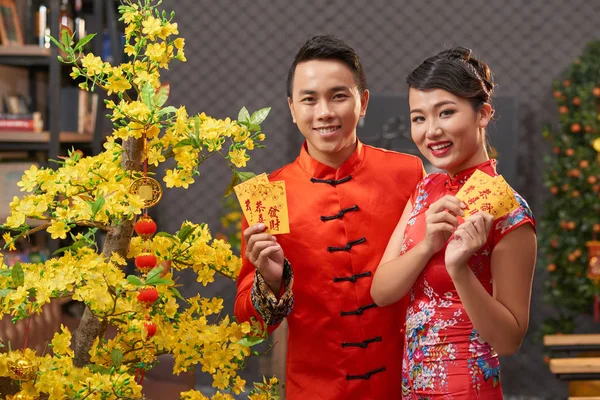 Loving Asian Couple Wearing Traditional Chinese Costumes Showing Colorful Envelopes — Stock Photo, Image