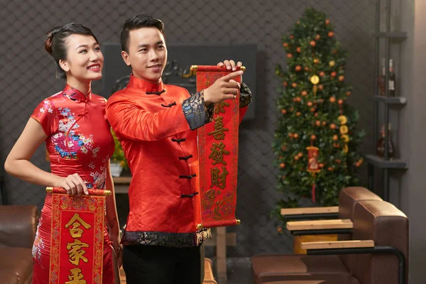 穿中国传统服饰的男子和女人用春联捧着卷轴 — 图库照片