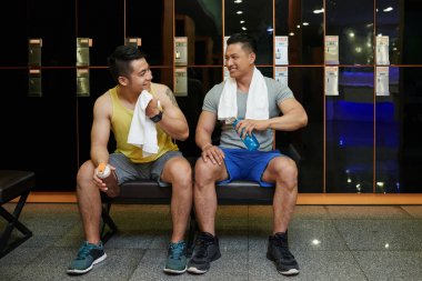 İçme suyu ve çalışma dışarı sonra spor salonu soyunma odasında konuşurken neşeli arkadaşları