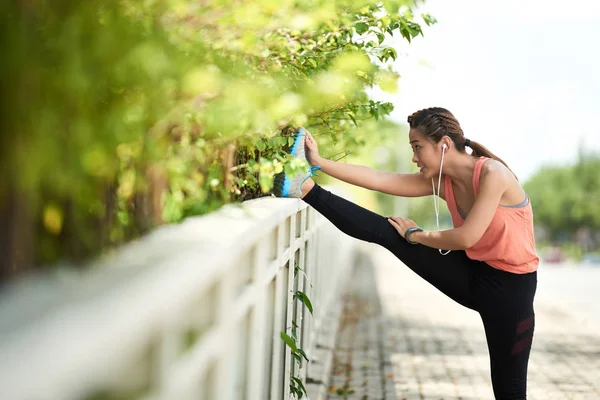 亚洲女性慢跑运动员训练后伸展腿部 — 图库照片