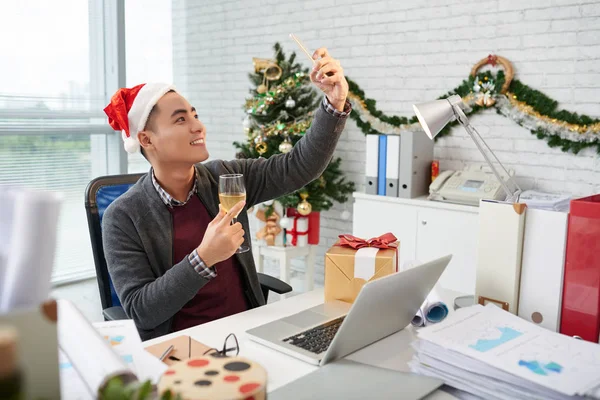 シャンパン グラスでクリスマス Selfie 職場でサンタ帽子でアジア系のビジネスマン — ストック写真