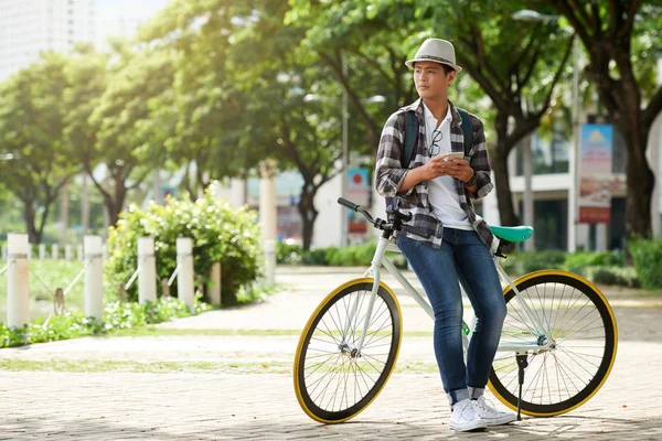 Homem Asiático Elegante Com Smartphone Inclinado Sua Bicicleta — Fotografia de Stock