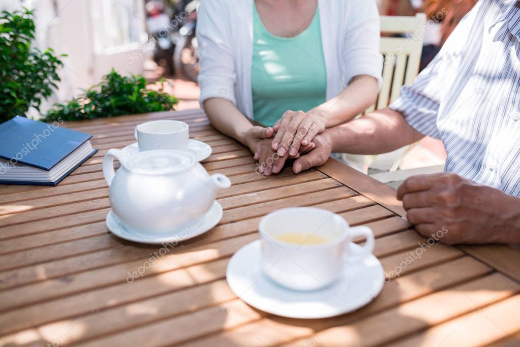 Woman touching hand of her father to support him