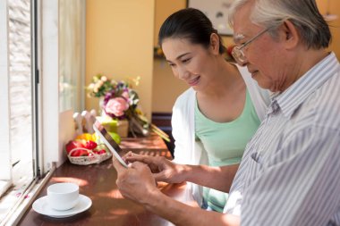 üst düzey Asya adam kızı evde dijital tablet kullanma