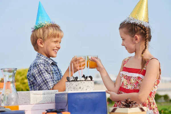 快乐的小孩子的外形视图在生日聚会上享受快乐的时候 用橙汁举杯庆祝 背景蓝色万里无云的天空 — 图库照片