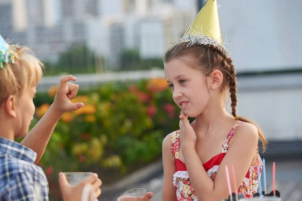 漂亮的小女孩听她的男性朋友的兴趣 而享受生日聚会 — 图库照片