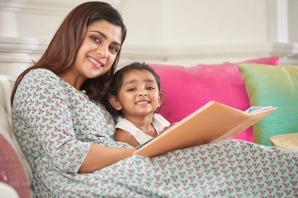 快乐的印度妇女和她的小女儿的肖像一起读一本书 — 图库照片
