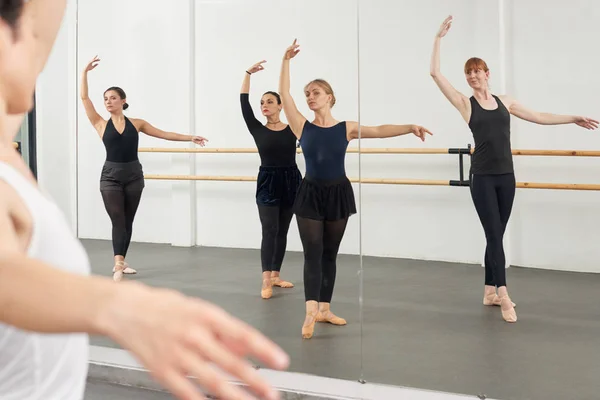 Young women in ballet school with instructor