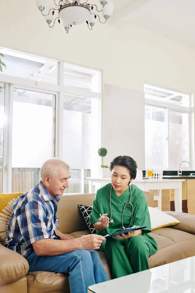 Nurse Visiting Elderly Patient Home Asking Him Questions Fill Form — Stock Photo, Image