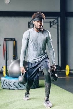 Kararlı zinde bir adam iki elinde ağır su tabancalarıyla saldırıyor.