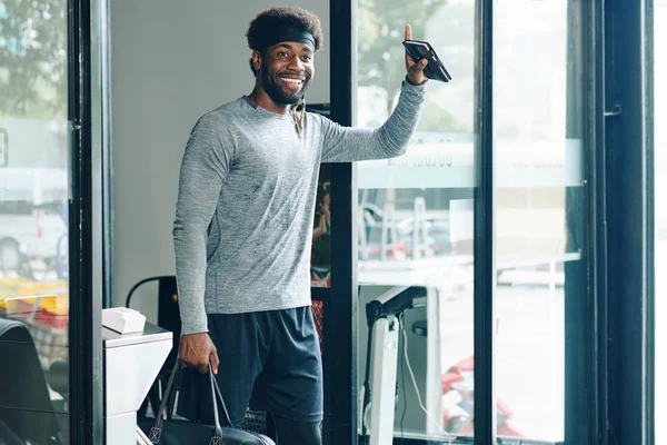 Positive young Black man saying bye to everybody after when leaving gym after intense training