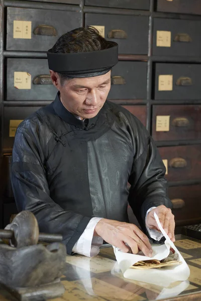 Mature Asian Drugstore Worker Using Paper Sheet Wrap Dry Shiitake — Stock Photo, Image