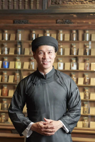 Pozytywny Dojrzały Wietnamczyk Czarnym Tradycyjnym Stroju Pracujący Starym Azjatyckim Sklepie — Zdjęcie stockowe