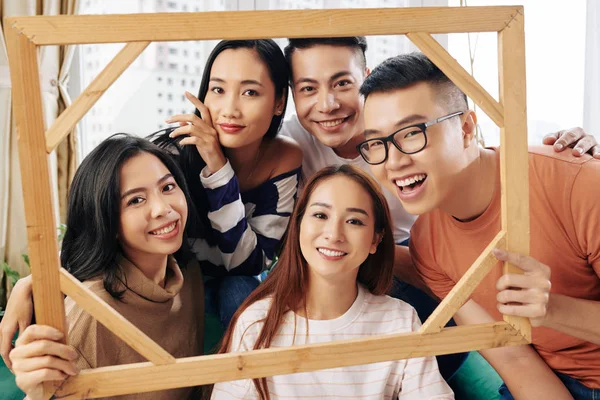 Groep Vrolijke Vriendelijke Jonge Aziaten Met Houten Fotolijstje Poseren Voor — Stockfoto