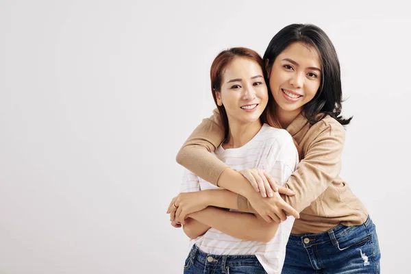 Mujer Vietnamita Sonriente Bastante Joven Abrazando Mejor Amiga Por Detrás —  Fotos de Stock