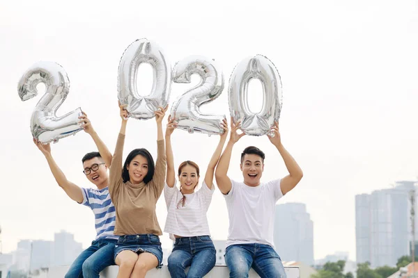 Vrolijke Jonge Vietnamezen Zitten Het Dak Tonen Folie 2020 Ballonnen — Stockfoto