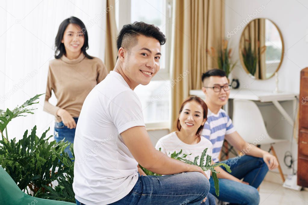 Portrait of handsome young Vietnamese man visiting friends at home
