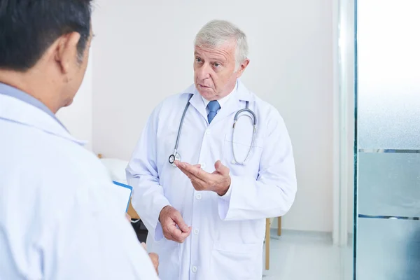 Starší Lékař Stetoskopem Mluvit Svým Kolegou Pomáhá Jeho Definovat Diagnózu — Stock fotografie