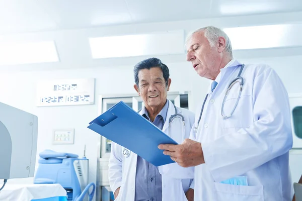 Doctor Mostrando Historial Médico Paciente Compañero Trabajo Vietnamita Pidiendo Consejo — Foto de Stock