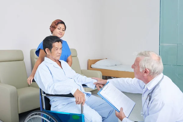 老人ホームの高齢者を訪問し 健康と回復のプロセスについて尋ねる医師 — ストック写真