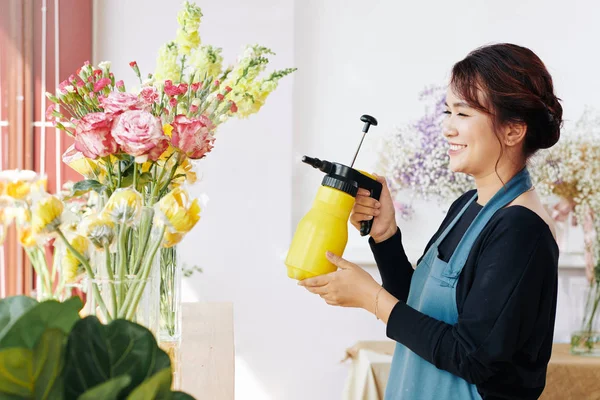 Vrolijke Jonge Bloemenwinkel Werknemer Spaying Verse Bloemen Glazen Vazen — Stockfoto