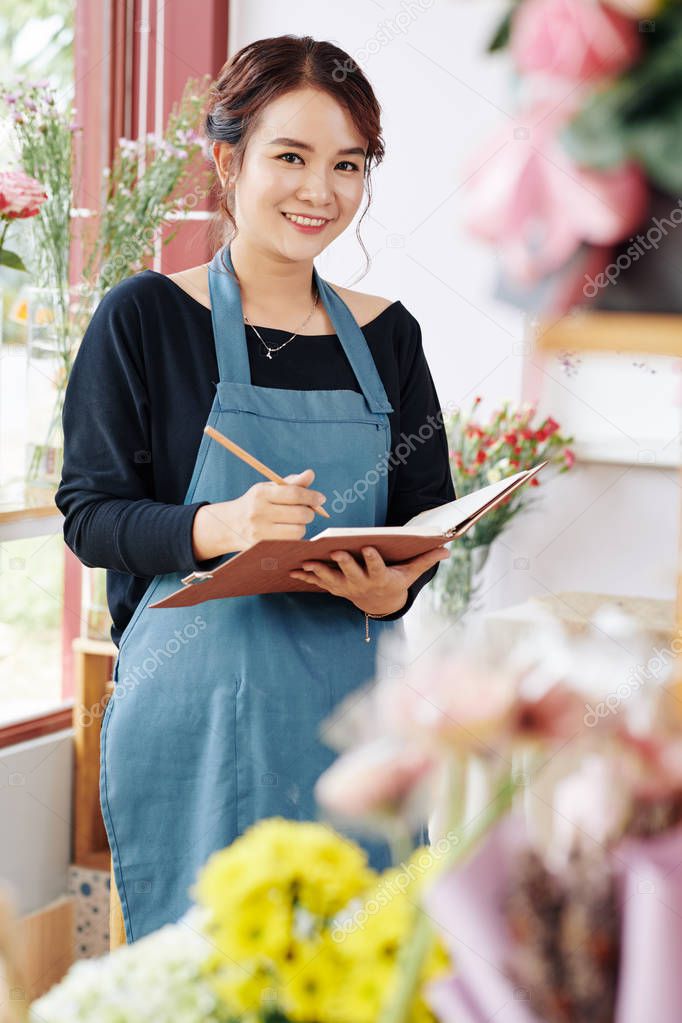 Portrait of young confident flower shop owner planning developments of her small business