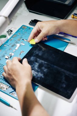 Çalışmayan tablet bilgisayarın ekranını kaldıran tamircinin süreci