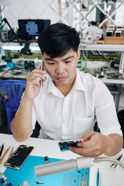 Confused Repairman Calling Coworker Having Some Problems Fixing Smartphone Customer — Stock Photo, Image