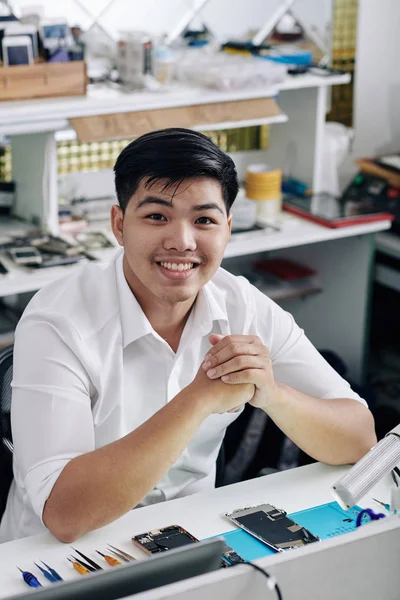 Alegre Guapo Joven Asiático Sentado Escritorio Con Teléfono Inteligente Desmontado — Foto de Stock