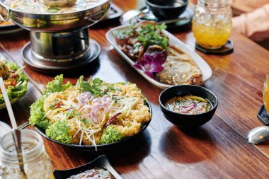 Japon usulü kızarmış karides, balık ve soba eriştesi ahşap yemek masasında.