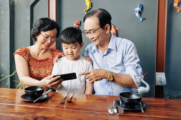 Senior Asian Couple Showing Mobile Application Grandson Sitting Cafe Table — Stok fotoğraf