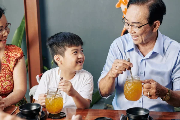 可爱的小男孩和祖父母一起在咖啡馆里休息 喝着甜可口的鸡尾酒 — 图库照片