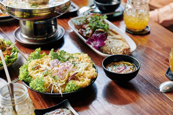 Japon usulü kızarmış karides, balık ve soba eriştesi ahşap yemek masasında.