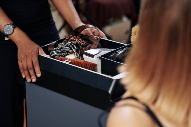 Kuaför kuaförünün kuaför arabasıyla saç aletleri ve aksesuarları iterken yakın plan görüntüsü.