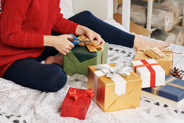 Imagen Recortada Mujer Joven Sentada Cama Cortando Cinta Regalo Navidad —  Fotos de Stock