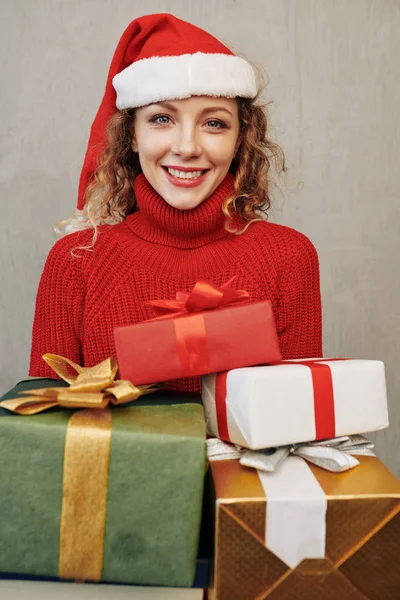 若いです美しいです笑顔女性の肖像画とともに包まれたクリスマスプレゼントとカメラを見て — ストック写真