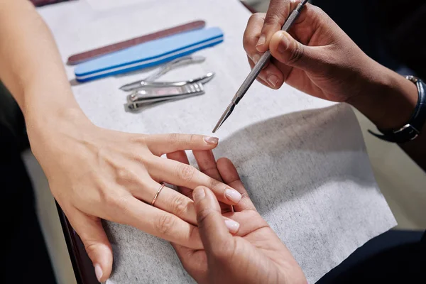 美容师在处理女性病人时使用角质层推推器的过程 从上往下看 — 图库照片