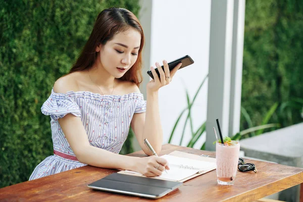 Jovem Vietnamita Ouvindo Mensagem Voz Seu Smartphone Tomando Notas Planejador — Fotografia de Stock