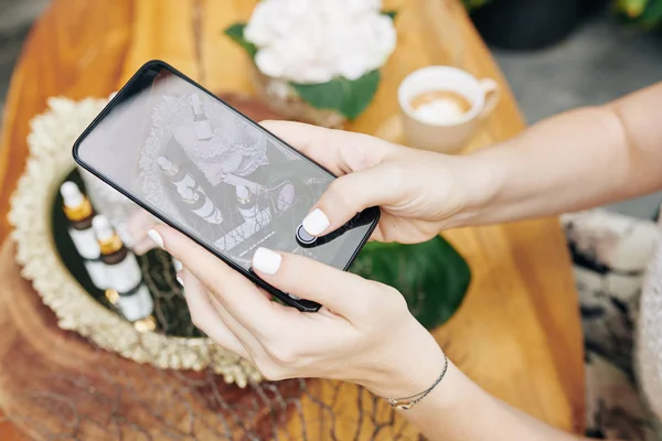 Hands of cosmetics brand owner taking photos of new products and uploading on social media or online shop