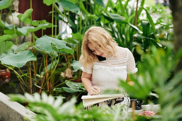 Креативна Молода Жінка Сидить Квітковому Саду Розмовляє Телефону Клієнтом Малює — стокове фото