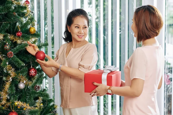 Žena Dává Dárek Její Usměvavé Starší Matka Zdobení Vánoční Strom — Stock fotografie