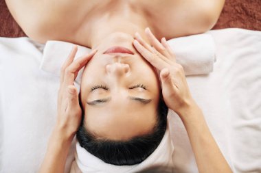 Güzellik salonunda yapılan spa yüz masajı prosedürü, yukarıdan görüş