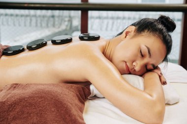 Genç Vietnamlı güzel bir kadın bazalt taşlarıyla spa ameliyatından zevk alıyor.