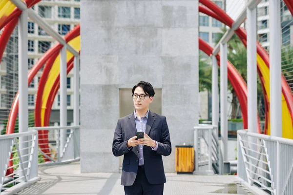 Pensive Säker Ung Asiatisk Man Kostym Står Bron Och Sms — Stockfoto