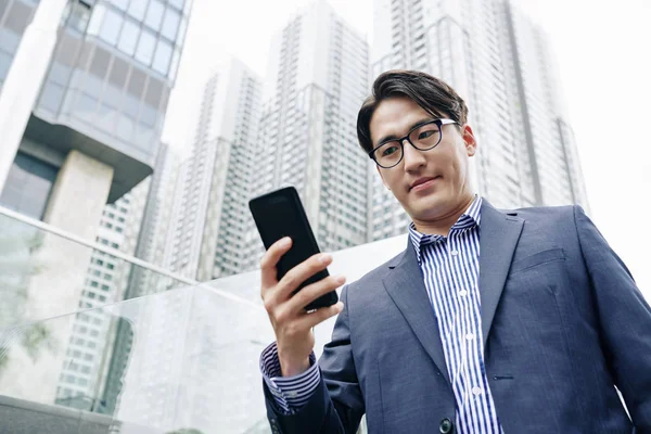 Sonriente Guapo Asiático Hombre Leyendo Notificación Pantalla Del Teléfono Inteligente — Foto de Stock