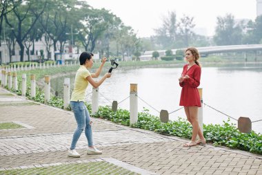 Şehir Nehri kıyısında akıllı telefondan video çeken iki bayan arkadaş.